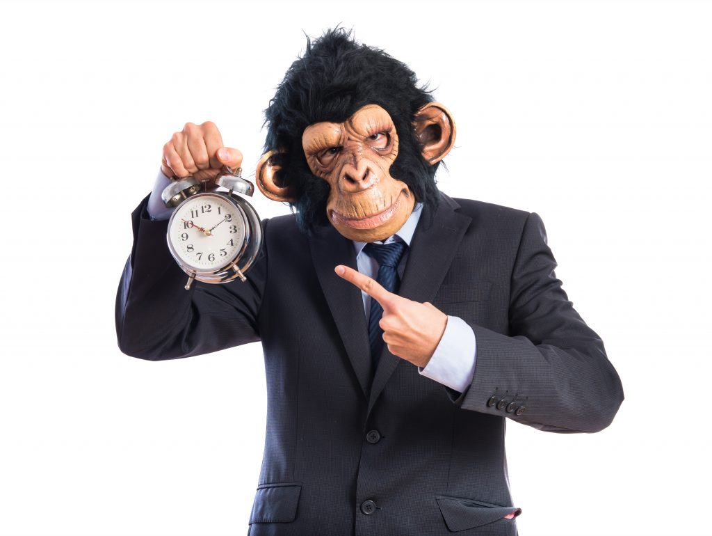 Hombre negocios con cara de mono y reloj en mano